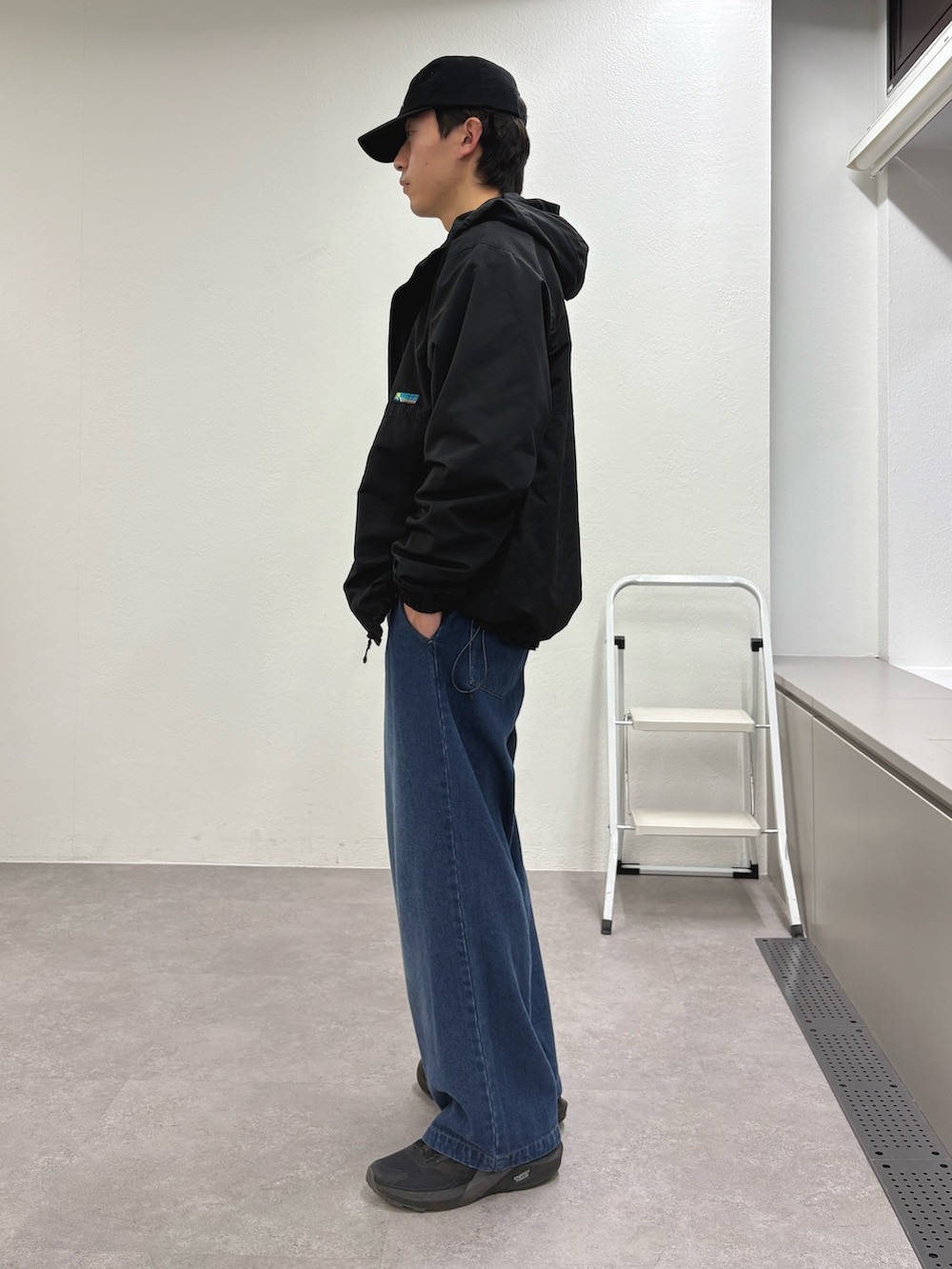 ブラック系のパーカー、グレー系のスウェット、ブルー系のデニムパンツを着用したメンズの冬コーディネートの2枚目の写真