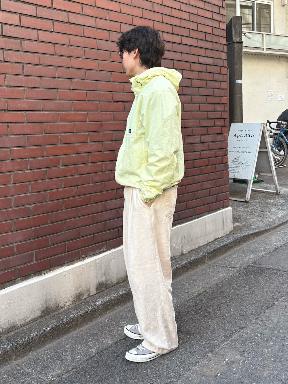 イエロー系のマウンテンパーカー、ホワイト系のその他パンツを着用したメンズの春コーディネートの2枚目の写真