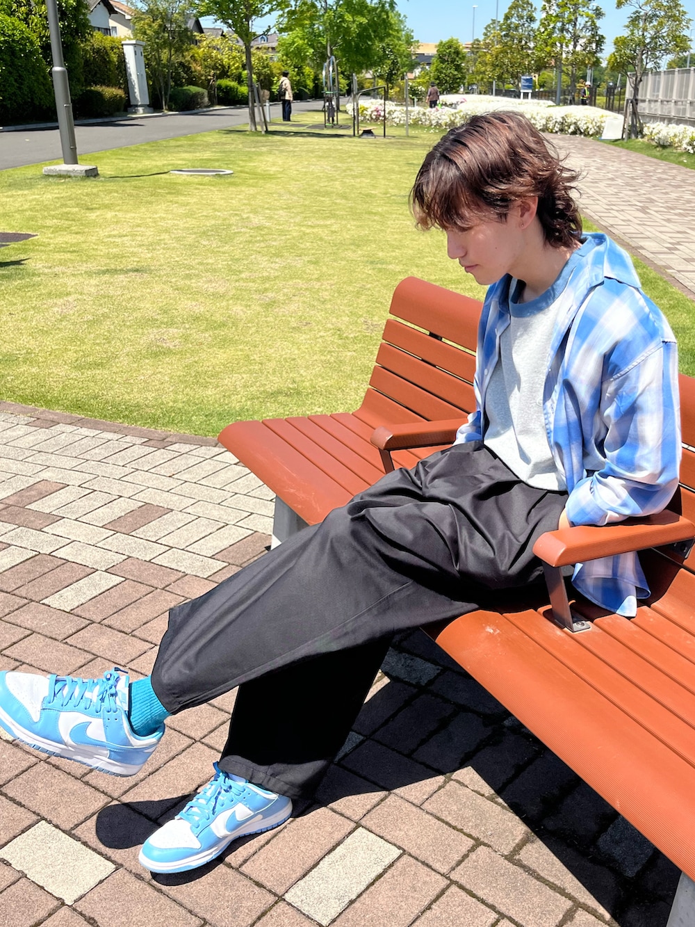 ブルー系のスニーカー、ブラック系のチノパンツ、その他のTシャツ/カットソーを着用したメンズの夏コーディネートの5枚目の写真