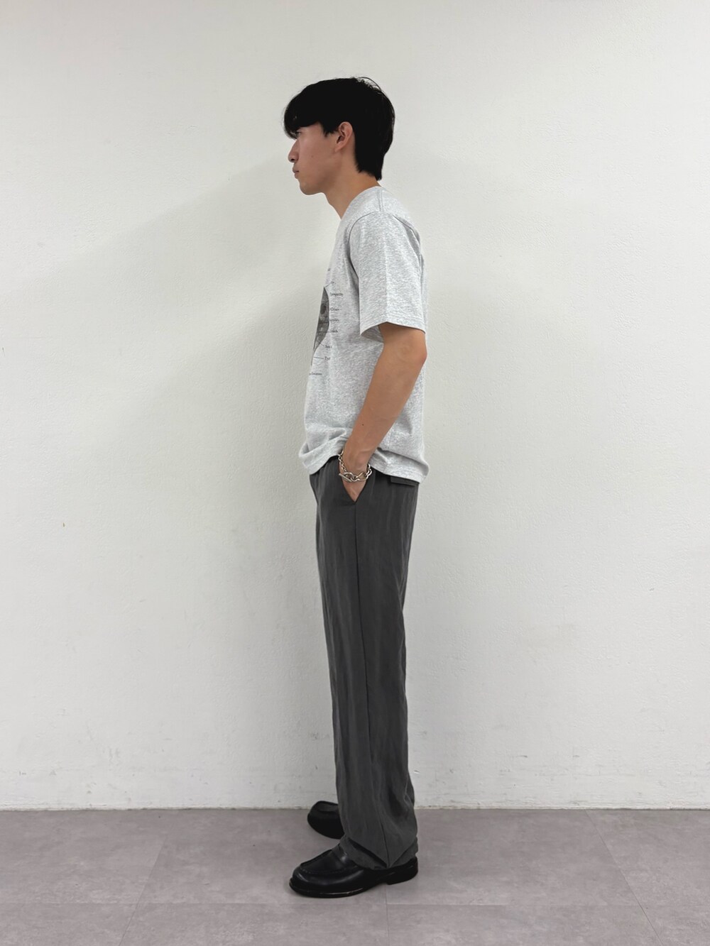 グレー系のTシャツ/カットソー、グレー系のスラックスを着用したメンズの夏コーディネートの2枚目の写真