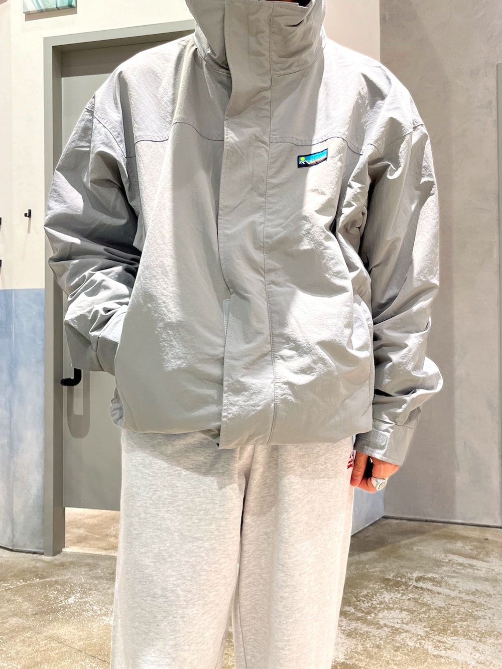 ブルー系のスニーカー、グレー系のスウェットパンツ、グレー系のナイロンジャケットを着用したメンズの冬コーディネートの3枚目の写真