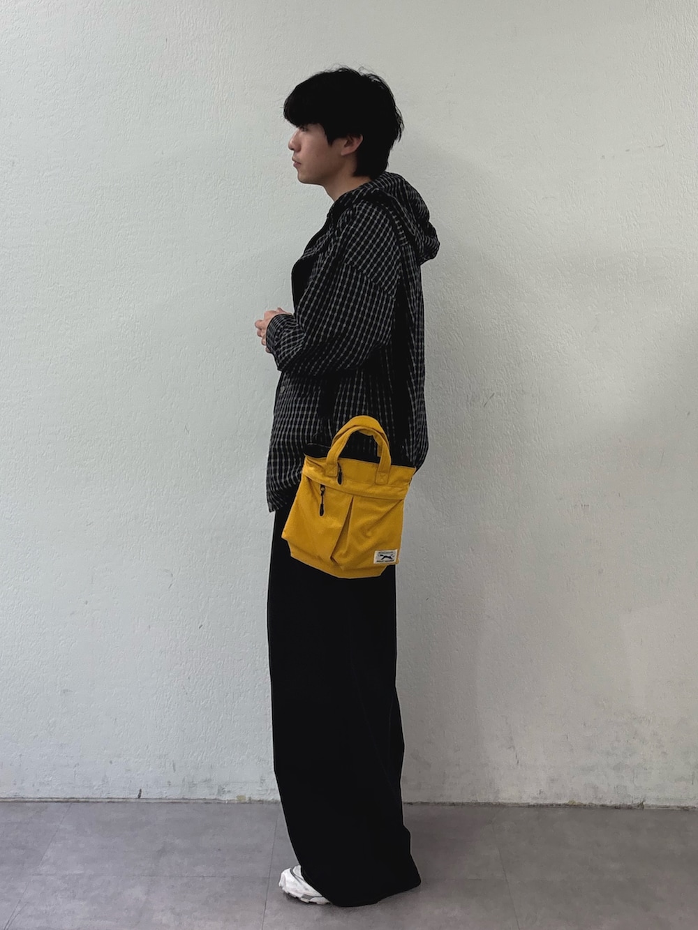 ブラック系のパーカー、ブラック系のTシャツ/カットソー、イエロー系のショルダーバッグを着用したメンズの春コーディネートの2枚目の写真