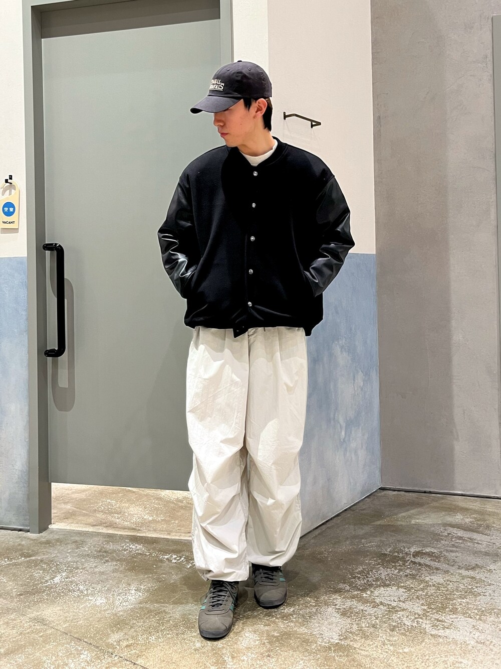 グレー系のスニーカー、グレー系のカーゴパンツ、ホワイト系のスウェットを着用したメンズの冬コーディネートの2枚目の写真