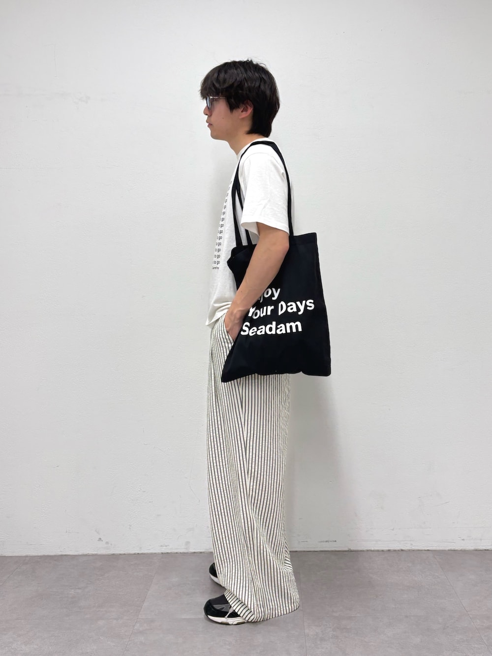 ホワイト系のTシャツ/カットソー、ブラック系のトートバッグ、ホワイト系のその他パンツを着用したメンズの春コーディネートの2枚目の写真