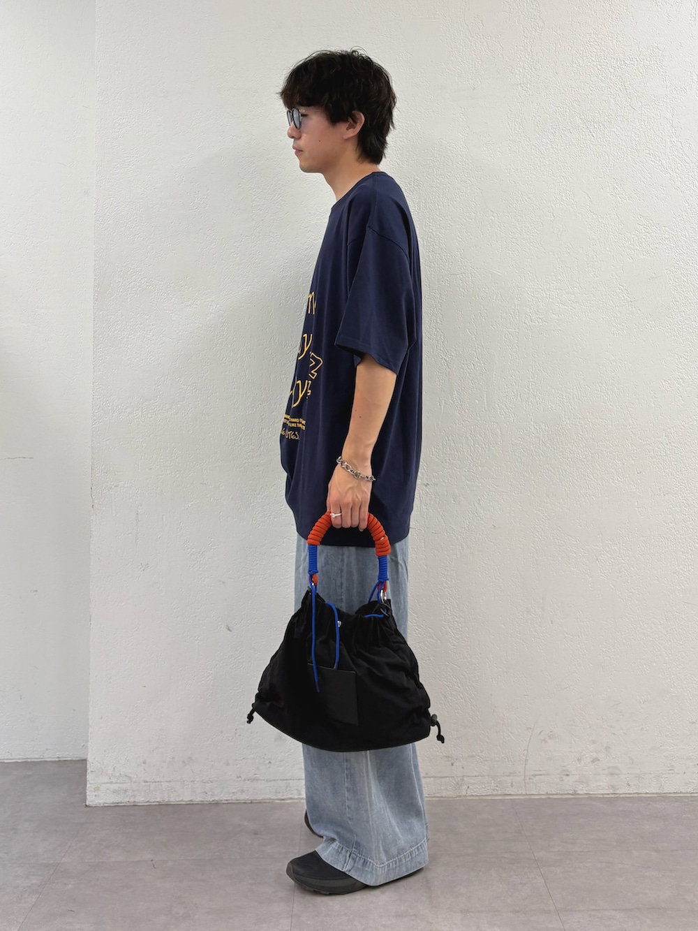 ブルー系のTシャツ/カットソー、ブラック系のトートバッグ、ブルー系のデニムパンツを着用したメンズの夏コーディネートの2枚目の写真
