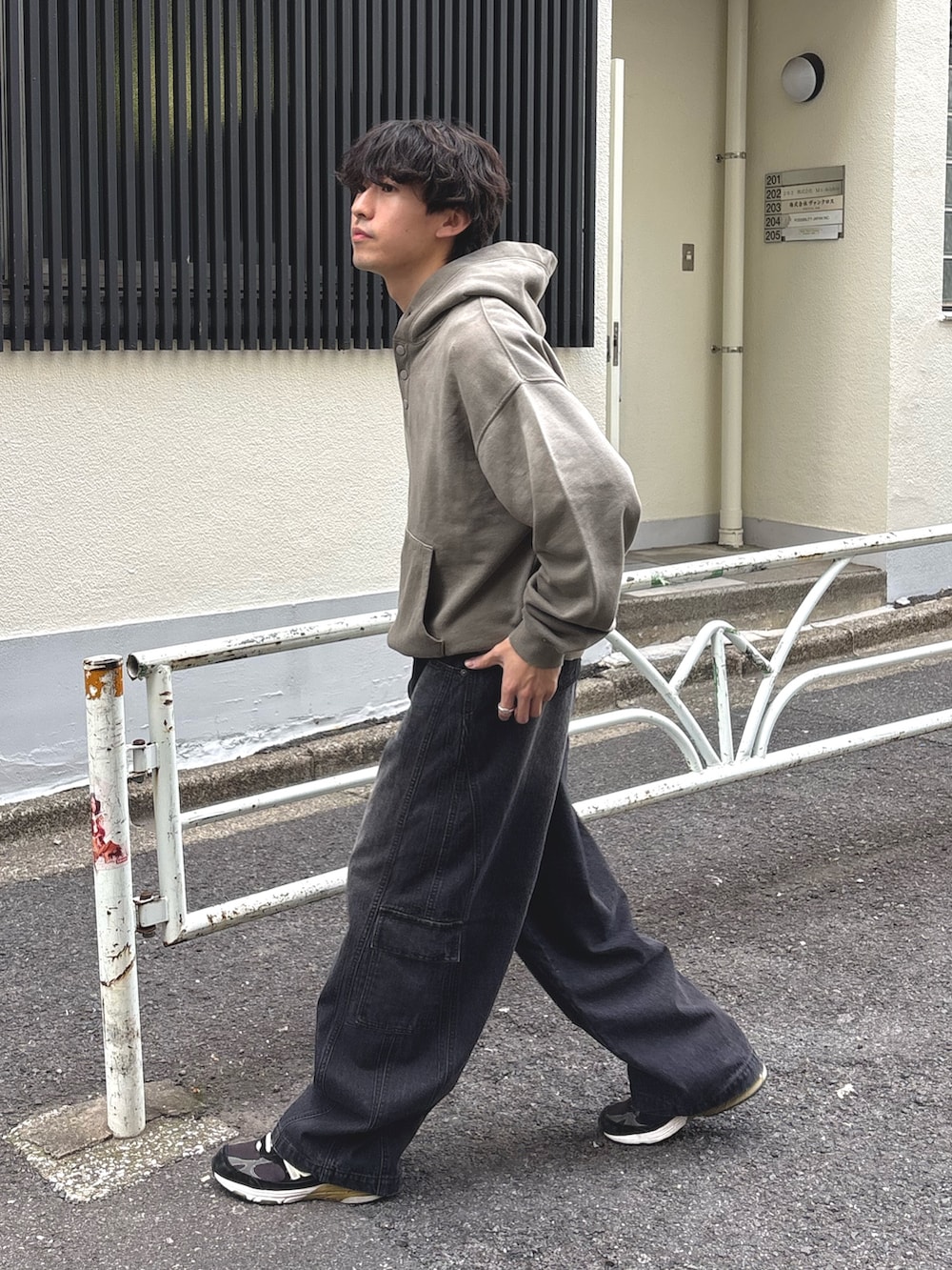 ベージュ系のパーカー、ブラック系のカーゴパンツを着用したメンズの冬コーディネートの2枚目の写真