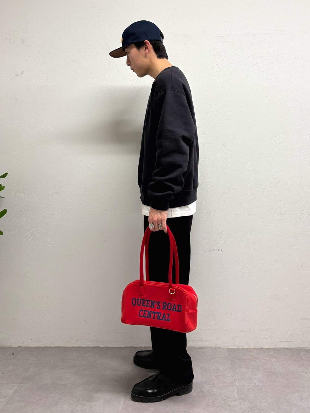 グレー系のスウェット、ブラック系のその他パンツ、レッド系のボストンバッグを着用したメンズの冬コーディネートの2枚目の写真