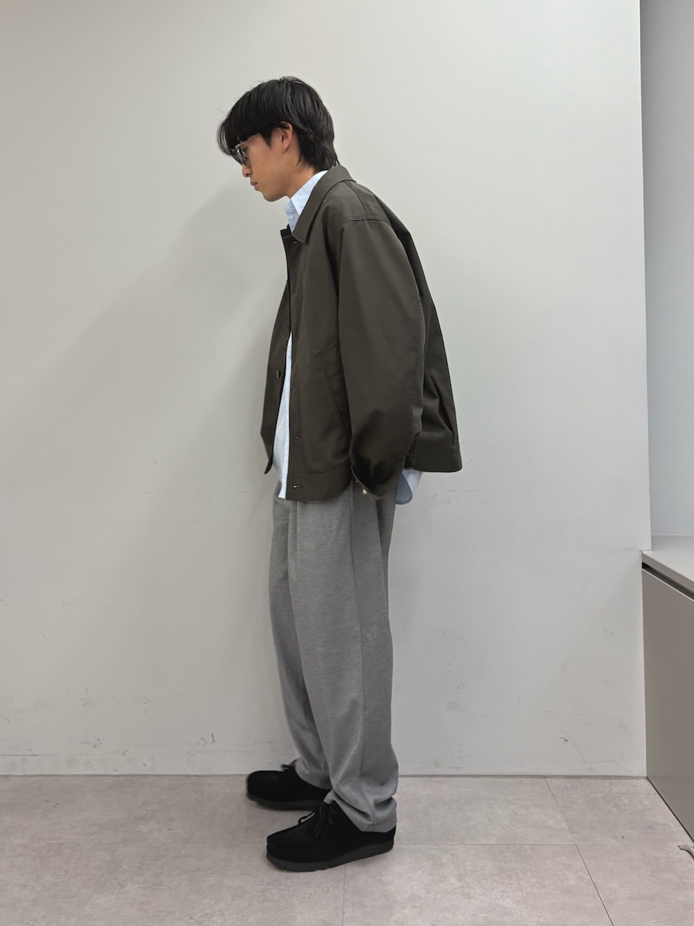 グレー系のブルゾン、ブルー系のシャツ/ブラウス、グレー系のスラックスを着用したメンズの春コーディネートの2枚目の写真