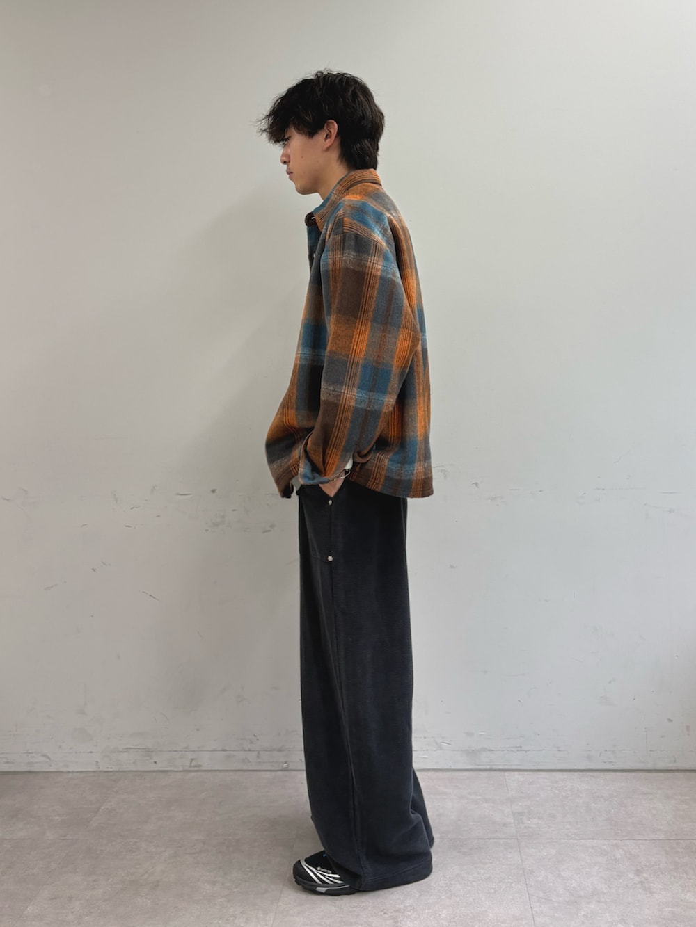 オレンジ系のシャツ/ブラウス、グレー系のTシャツ/カットソー、ブラック系のスウェットパンツを着用したメンズの秋コーディネートの2枚目の写真