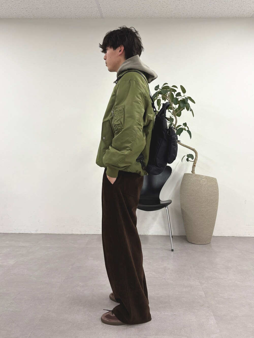 グリーン系のMA-1、ベージュ系のパーカー、ブラック系のショルダーバッグを着用したメンズの冬コーディネートの3枚目の写真