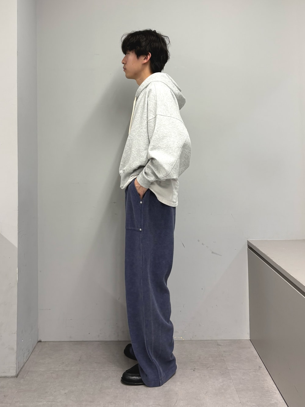 グレー系のパーカー、ブルー系のスウェットパンツを着用したメンズの春コーディネートの2枚目の写真