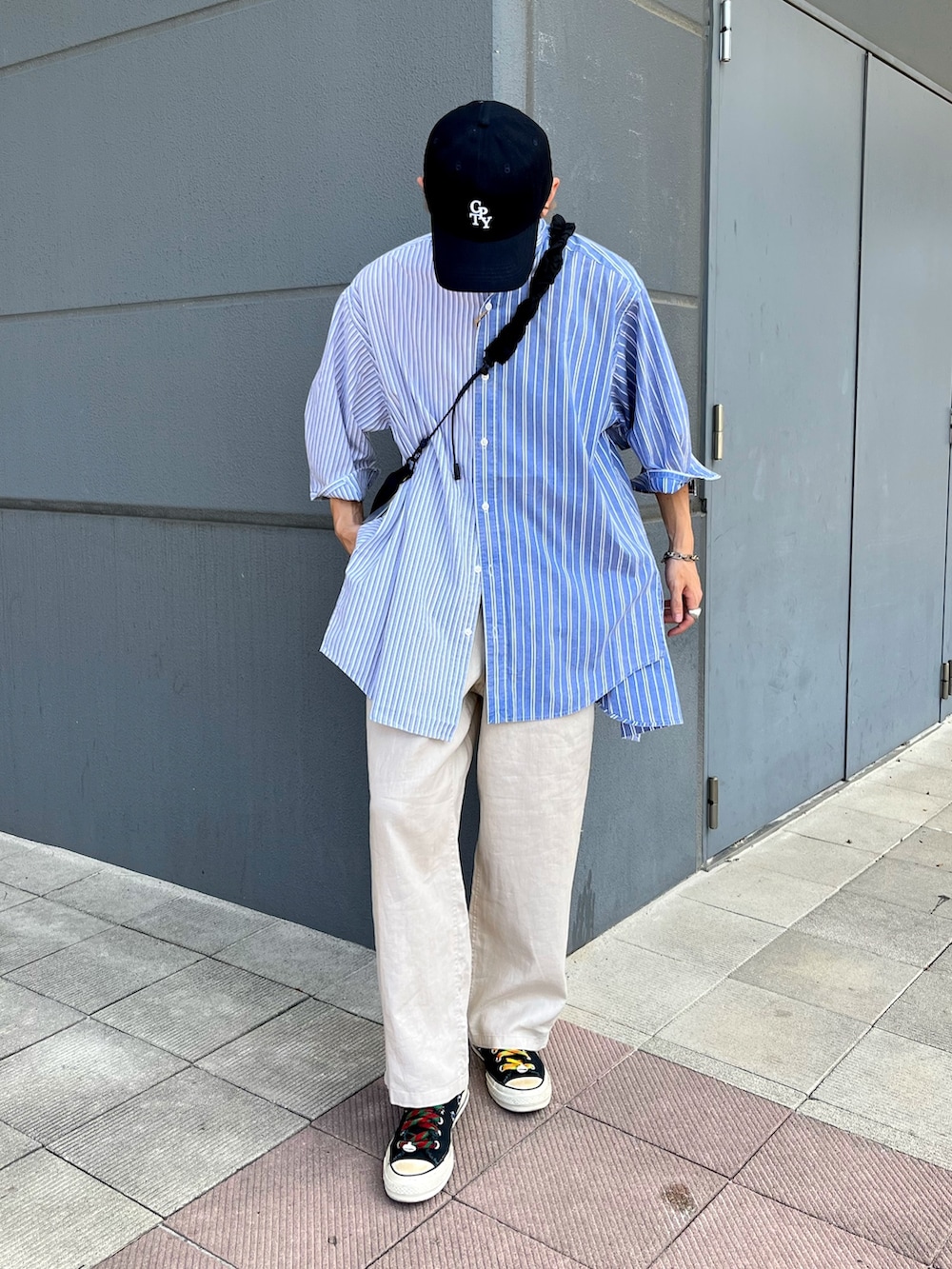 ブラック系のスニーカー、ベージュ系のその他パンツ、ブルー系のシャツ/ブラウスを着用したメンズの夏コーディネートの2枚目の写真