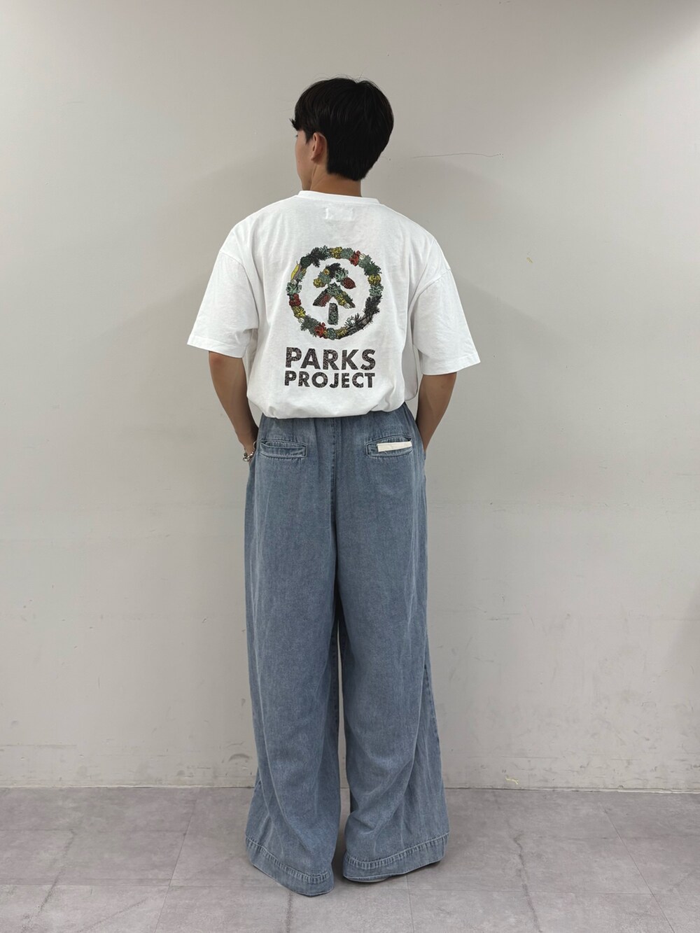 ホワイト系のTシャツ/カットソー、ブルー系のデニムパンツを着用したメンズの秋コーディネートの2枚目の写真