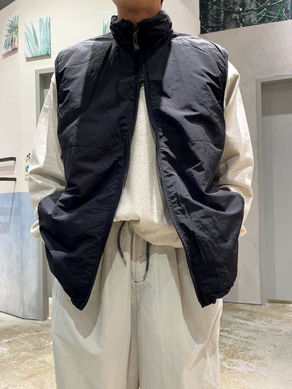 グレー系のスニーカー、グレー系のカーゴパンツ、ブラック系のベストを着用したメンズの冬コーディネートの3枚目の写真