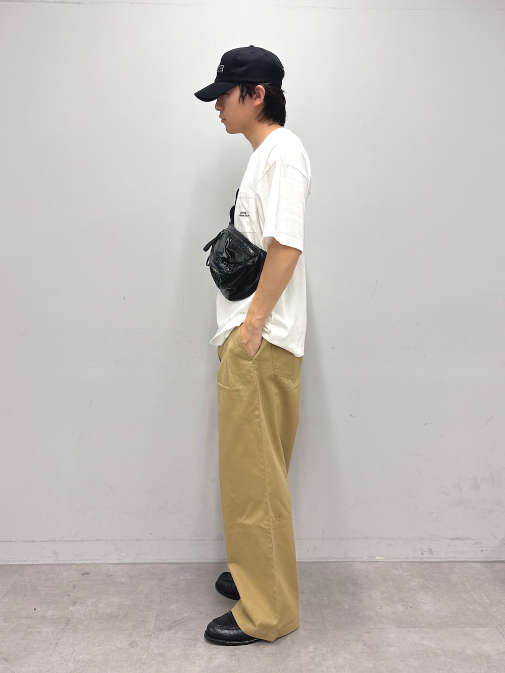 ホワイト系のTシャツ/カットソー、ブラック系のボディバッグ/ウエストポーチ、ベージュ系のデニムパンツを着用したメンズの春コーディネートの2枚目の写真