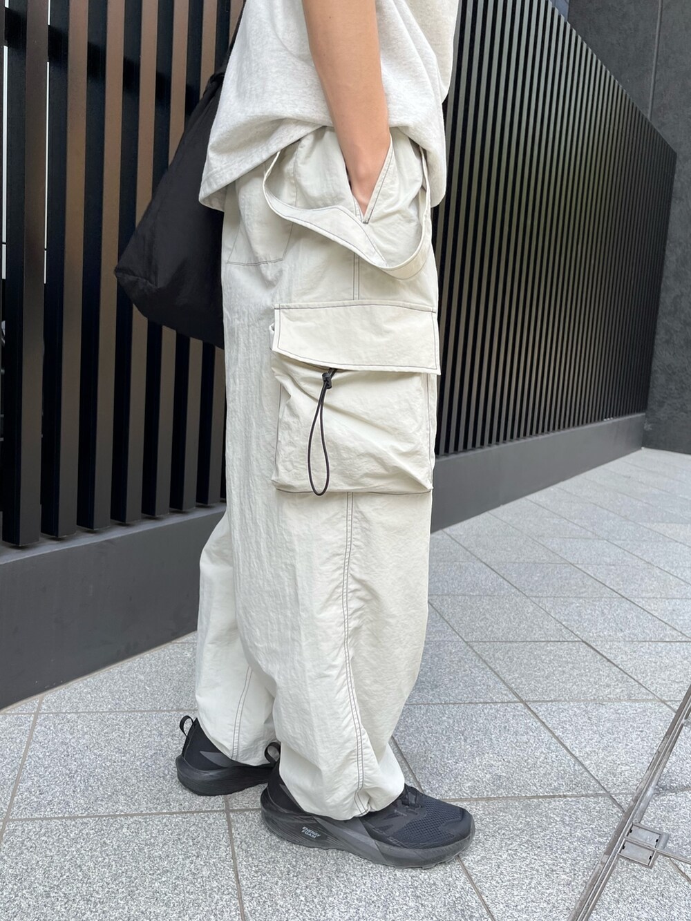 ブラック系のスニーカー、グレー系のサロペット/オーバーオール、ホワイト系のTシャツ/カットソーを着用したメンズの夏コーディネートの3枚目の写真