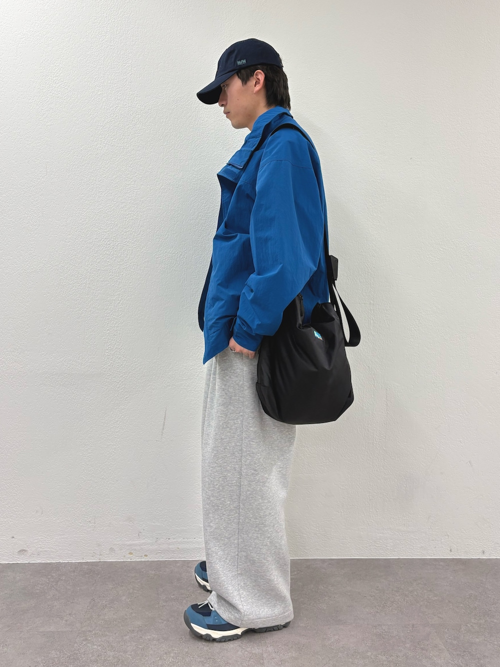 ブルー系のナイロンジャケット、ピンク系のシャツ/ブラウス、ブラック系のショルダーバッグを着用したメンズの冬コーディネートの2枚目の写真