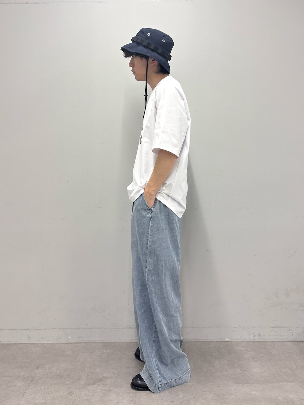 ホワイト系のTシャツ/カットソー、ブルー系のデニムパンツ、ブルー系のハットを着用したメンズの春コーディネートの2枚目の写真