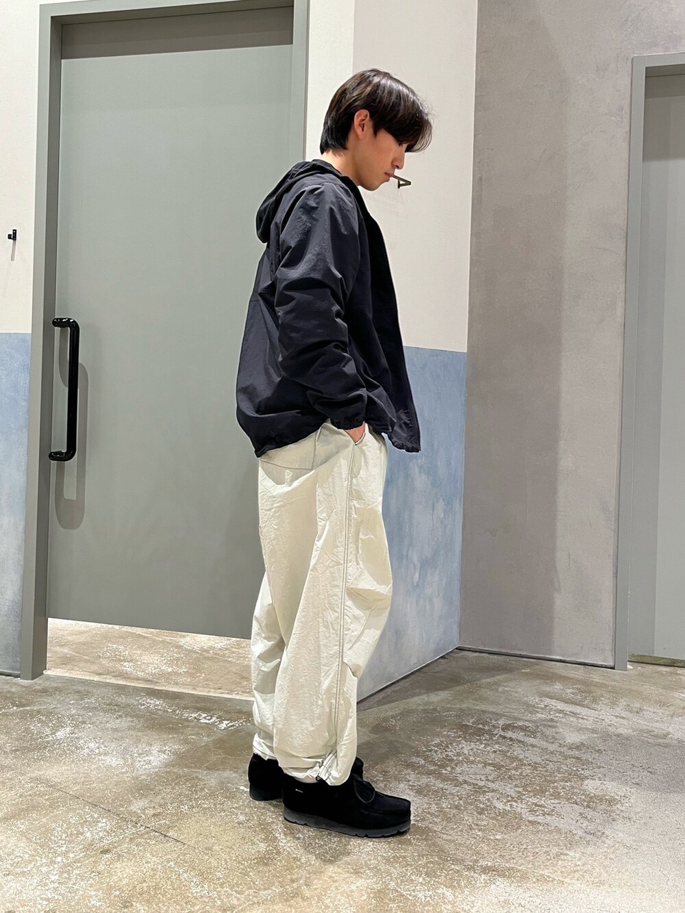 ブラック系のスニーカー、グレー系のカーゴパンツ、ブラック系のマウンテンパーカーを着用したメンズの春コーディネートの2枚目の写真