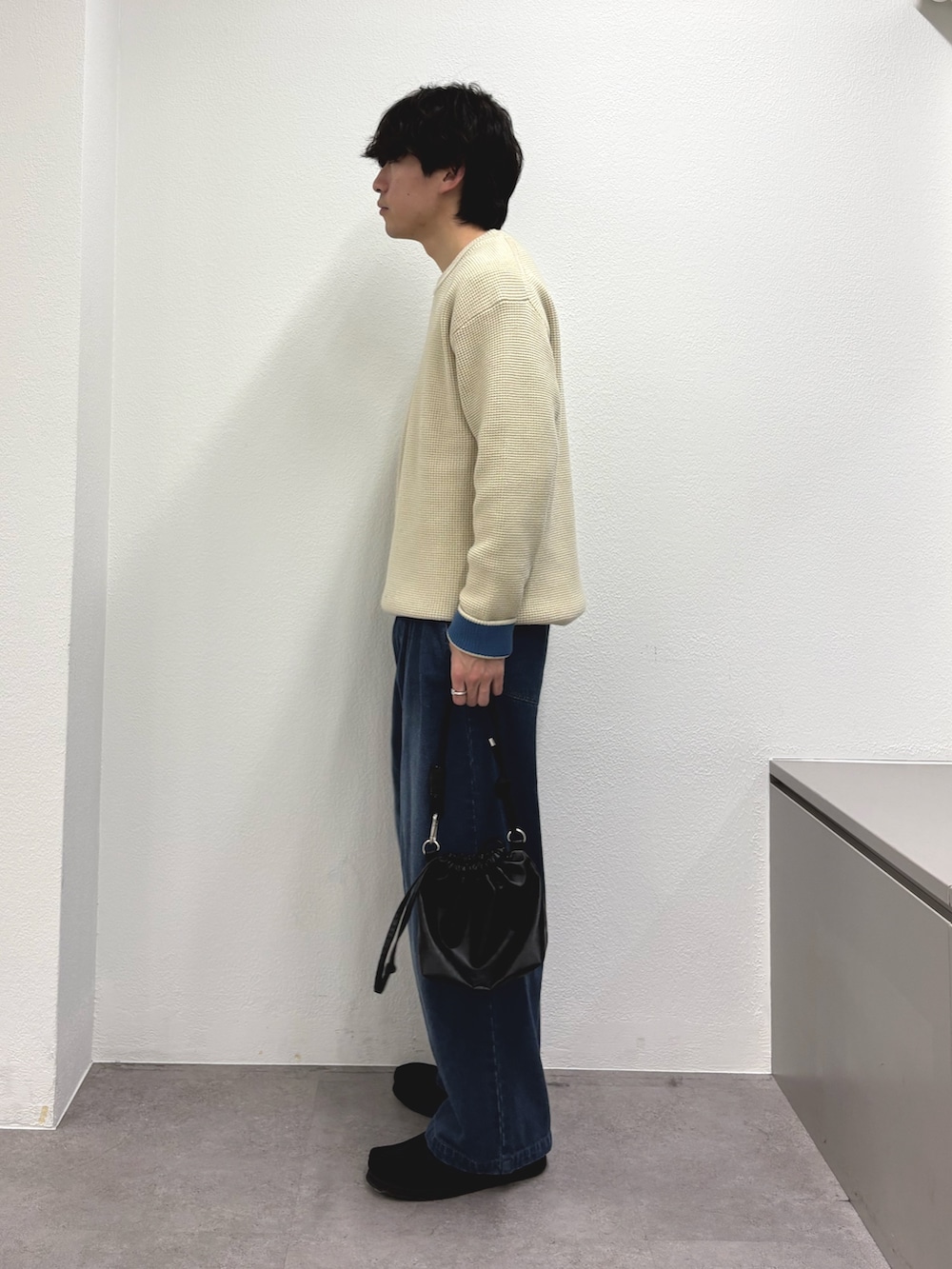 ホワイト系のニット/セーター、ブルー系のデニムパンツ、ブラック系のショルダーバッグを着用したメンズの冬コーディネートの2枚目の写真