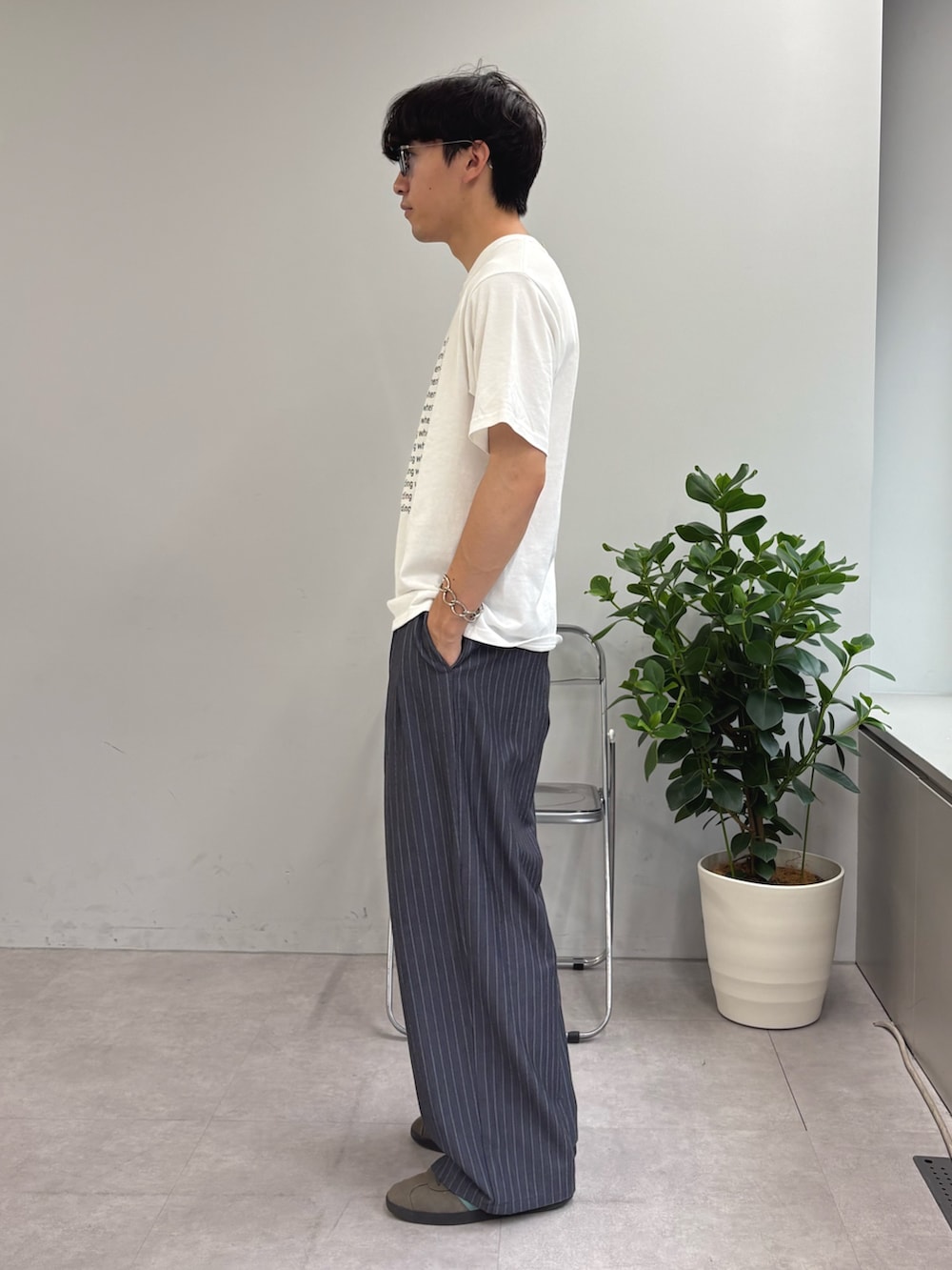 ホワイト系のTシャツ/カットソー、グレー系のスラックスを着用したメンズの春コーディネートの2枚目の写真