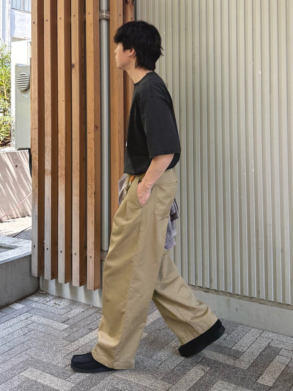 ブラック系のTシャツ/カットソー、ベージュ系のデニムパンツを着用したメンズの春コーディネートの2枚目の写真