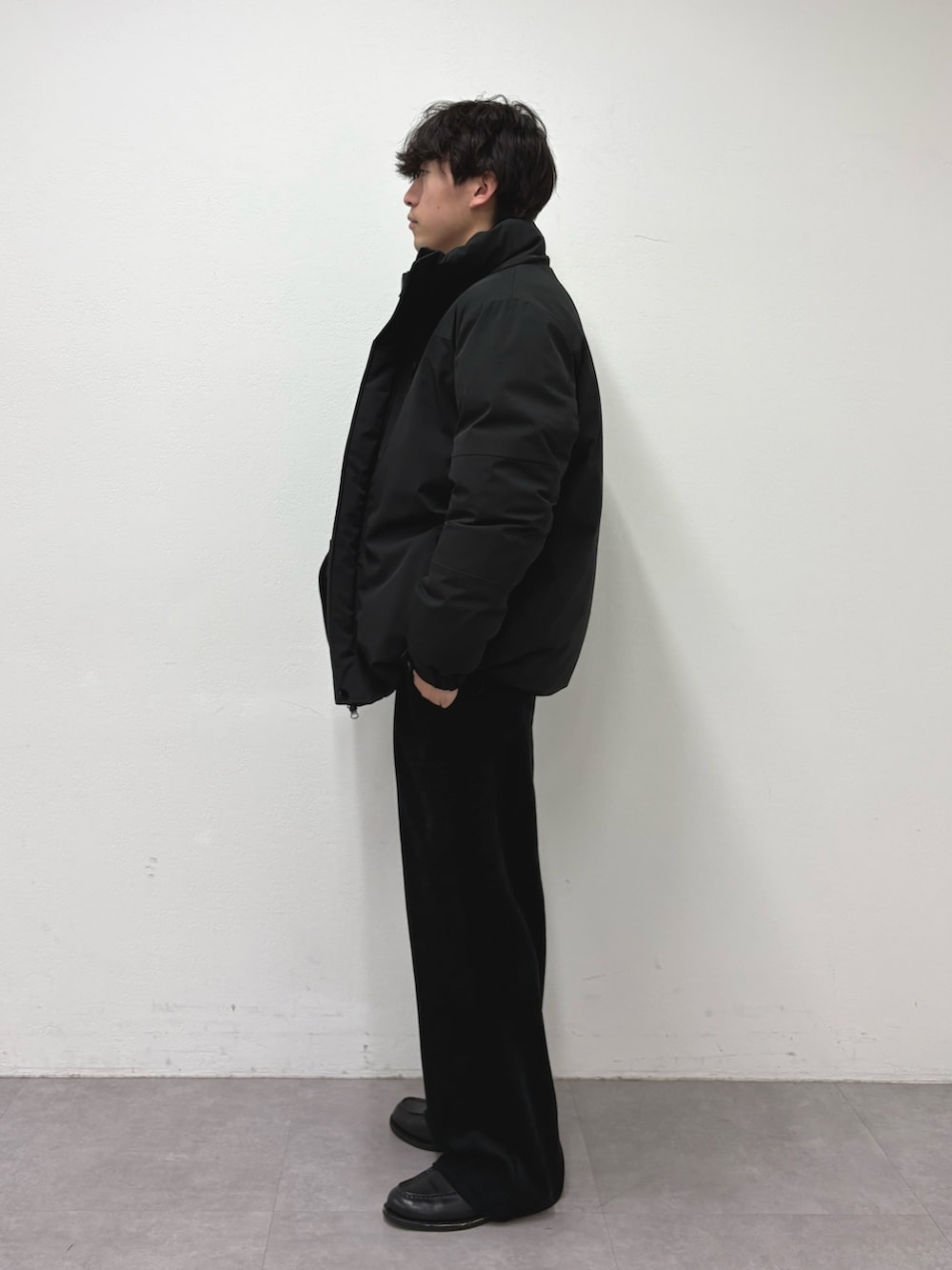 ブラック系のダウンジャケット/コート、グレー系のニット/セーター、ブラック系のその他パンツを着用したメンズの冬コーディネートの2枚目の写真