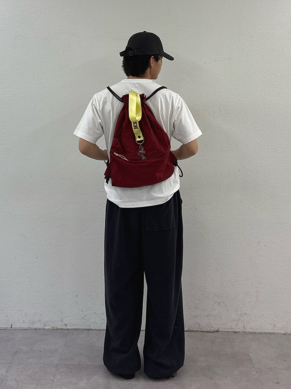 ブラック系のスウェットパンツ、ホワイト系のTシャツ/カットソー、レッド系のバックパック/リュックを着用したメンズの春コーディネートの3枚目の写真