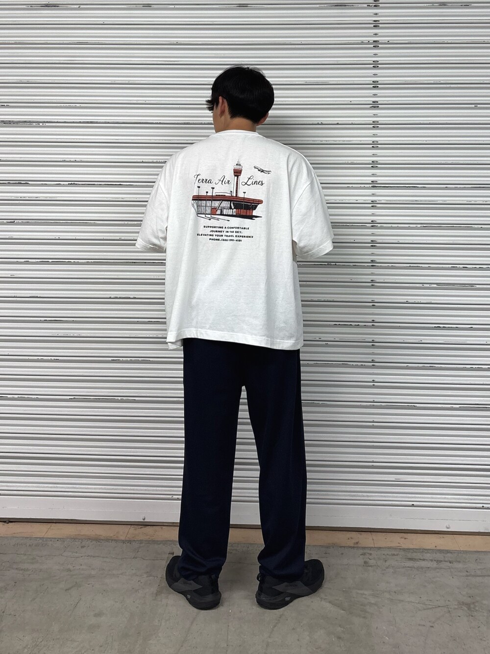 ホワイト系のTシャツ/カットソー、ブルー系のスラックスを着用したメンズの夏コーディネートの3枚目の写真