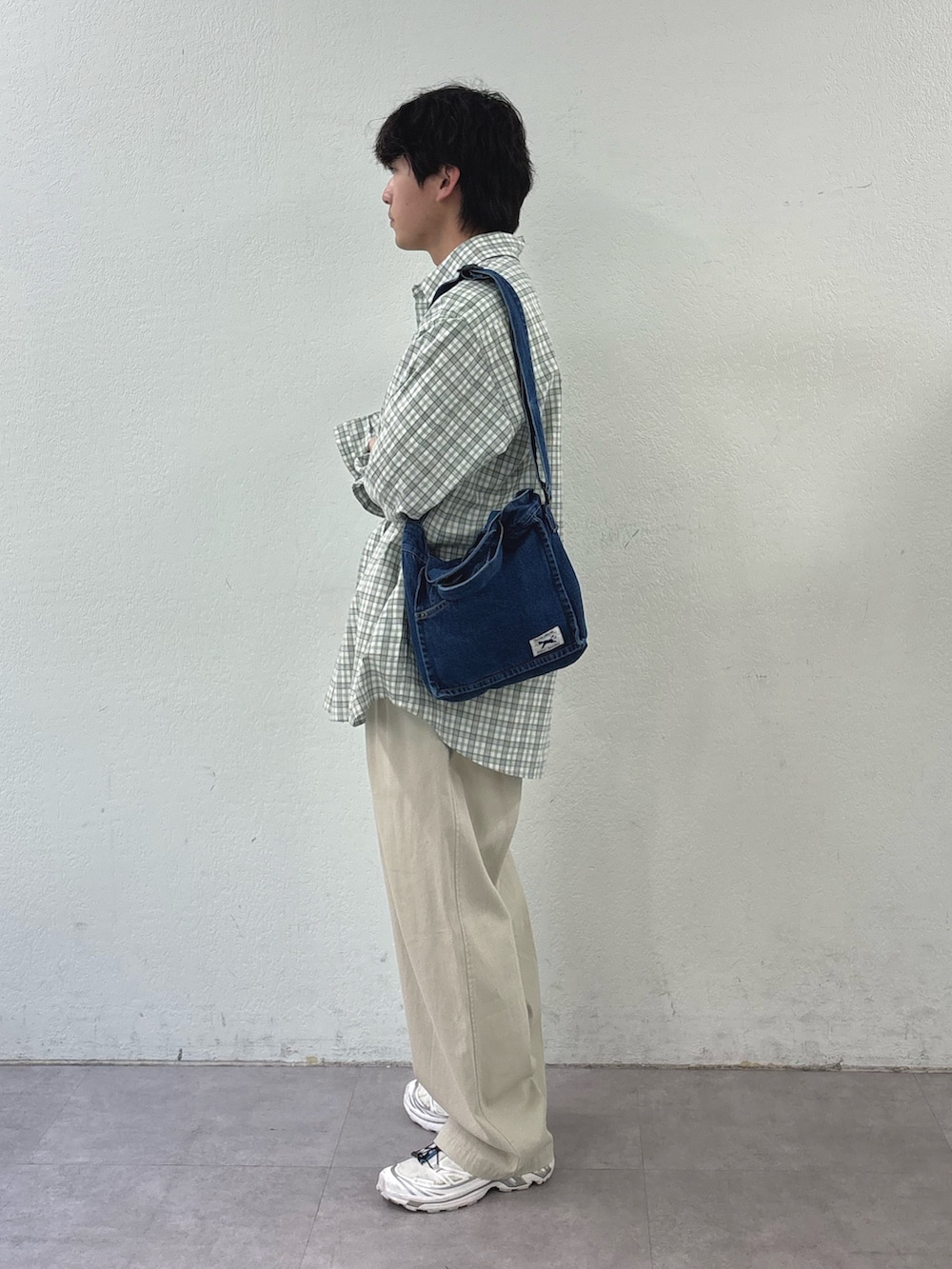 グリーン系のシャツ/ブラウス、ブルー系のショルダーバッグ、ホワイト系のチノパンツを着用したメンズの春コーディネートの2枚目の写真