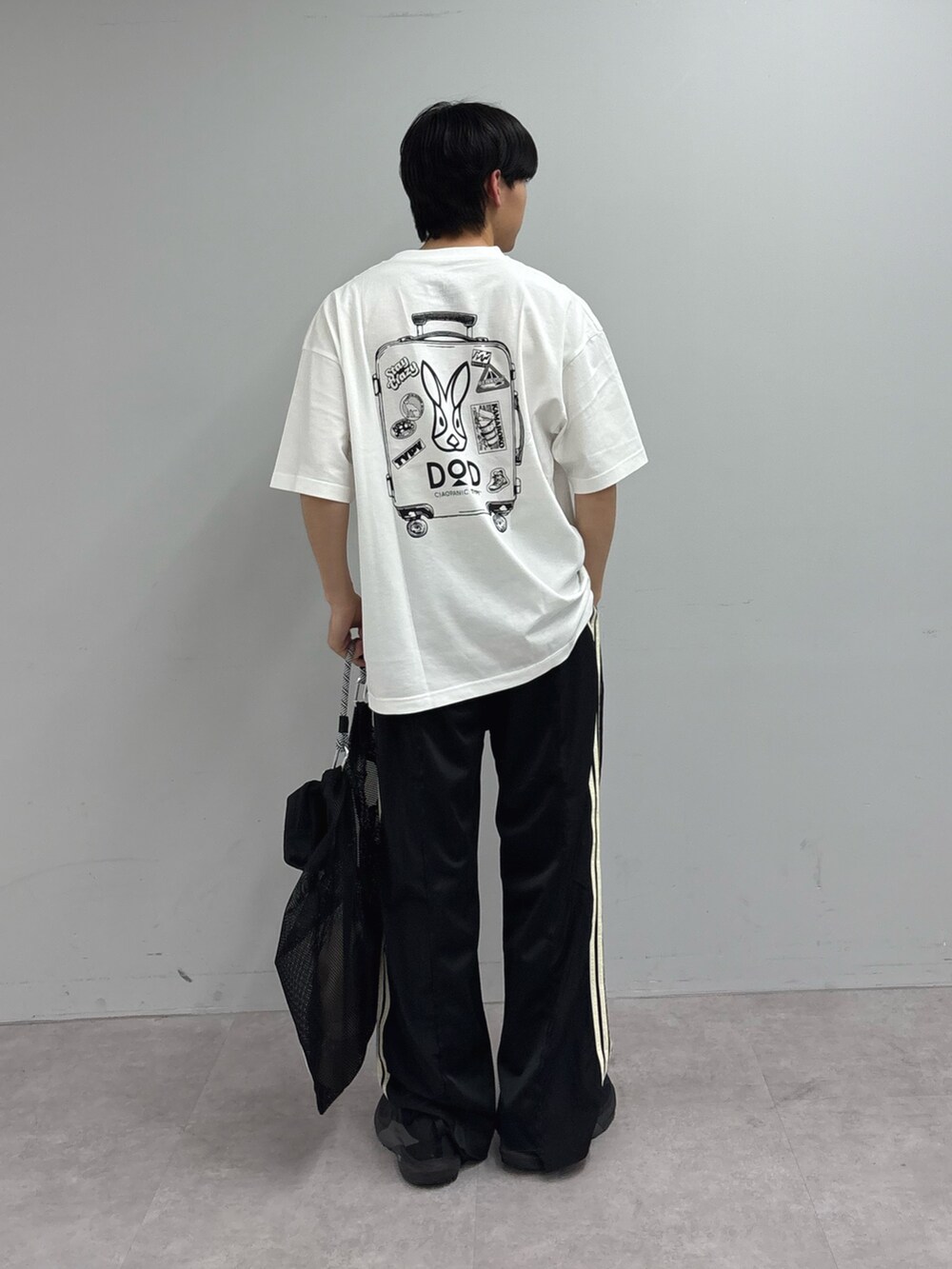 ホワイト系のTシャツ/カットソー、ブラック系のトートバッグ、ブラック系のスウェットパンツを着用したメンズの春コーディネートの2枚目の写真