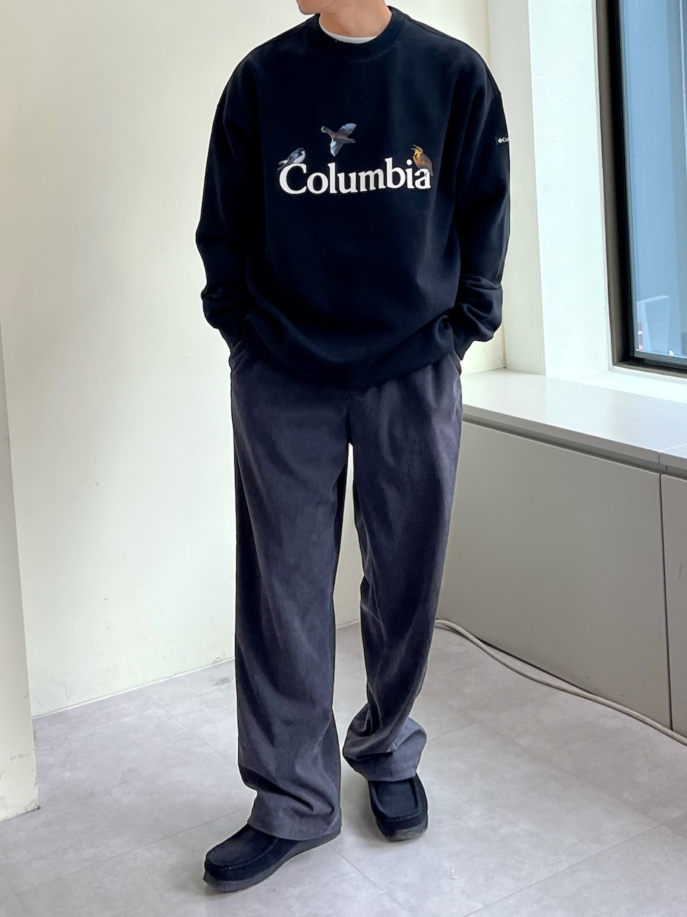 ブラック系のスウェット、グレー系のスーツパンツ、ブラック系のスニーカーを着用したメンズの秋コーディネートの2枚目の写真