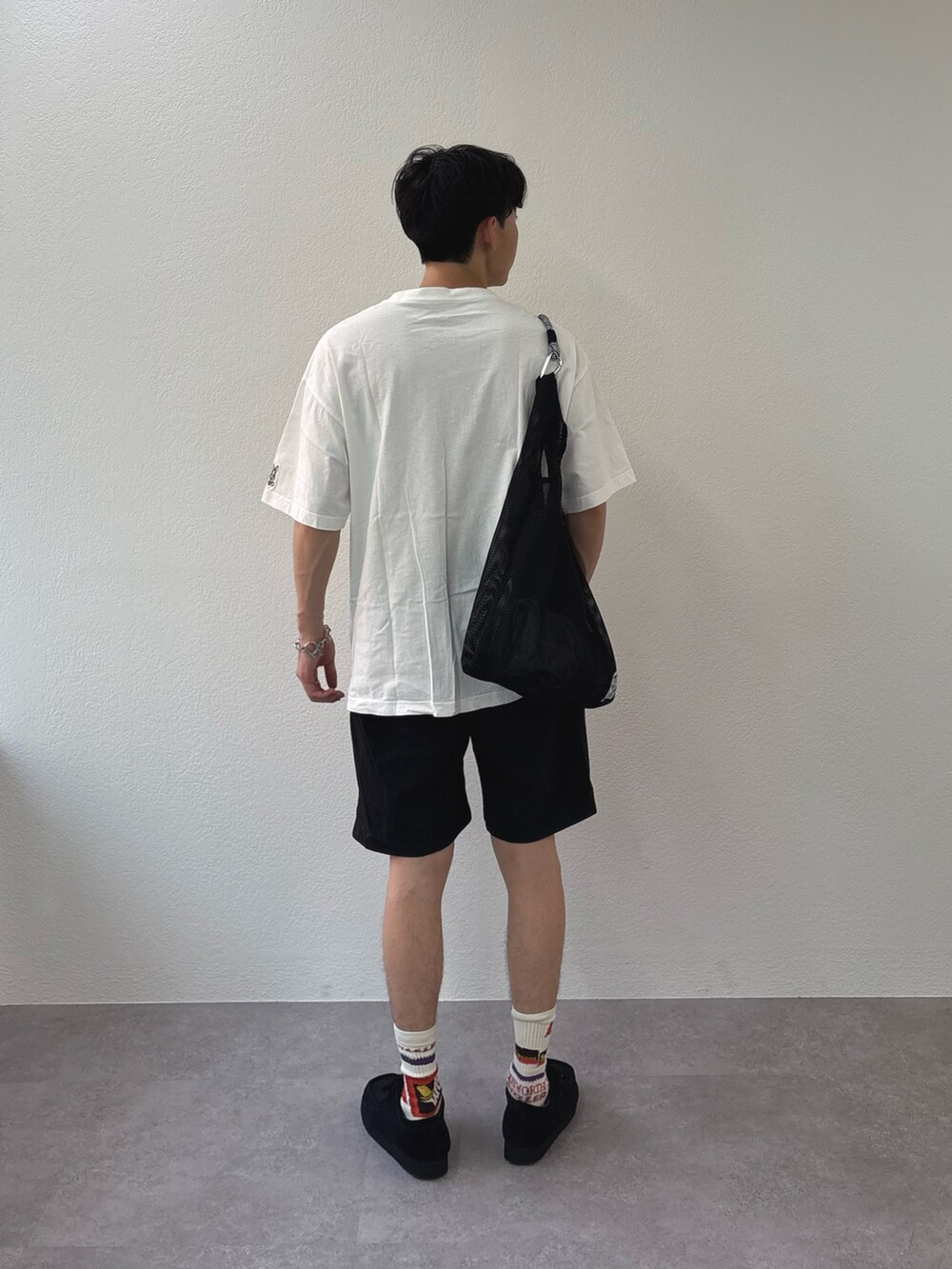 ホワイト系のTシャツ/カットソー、ブラック系のその他パンツ、ブラック系のトートバッグを着用したメンズの春コーディネートの3枚目の写真