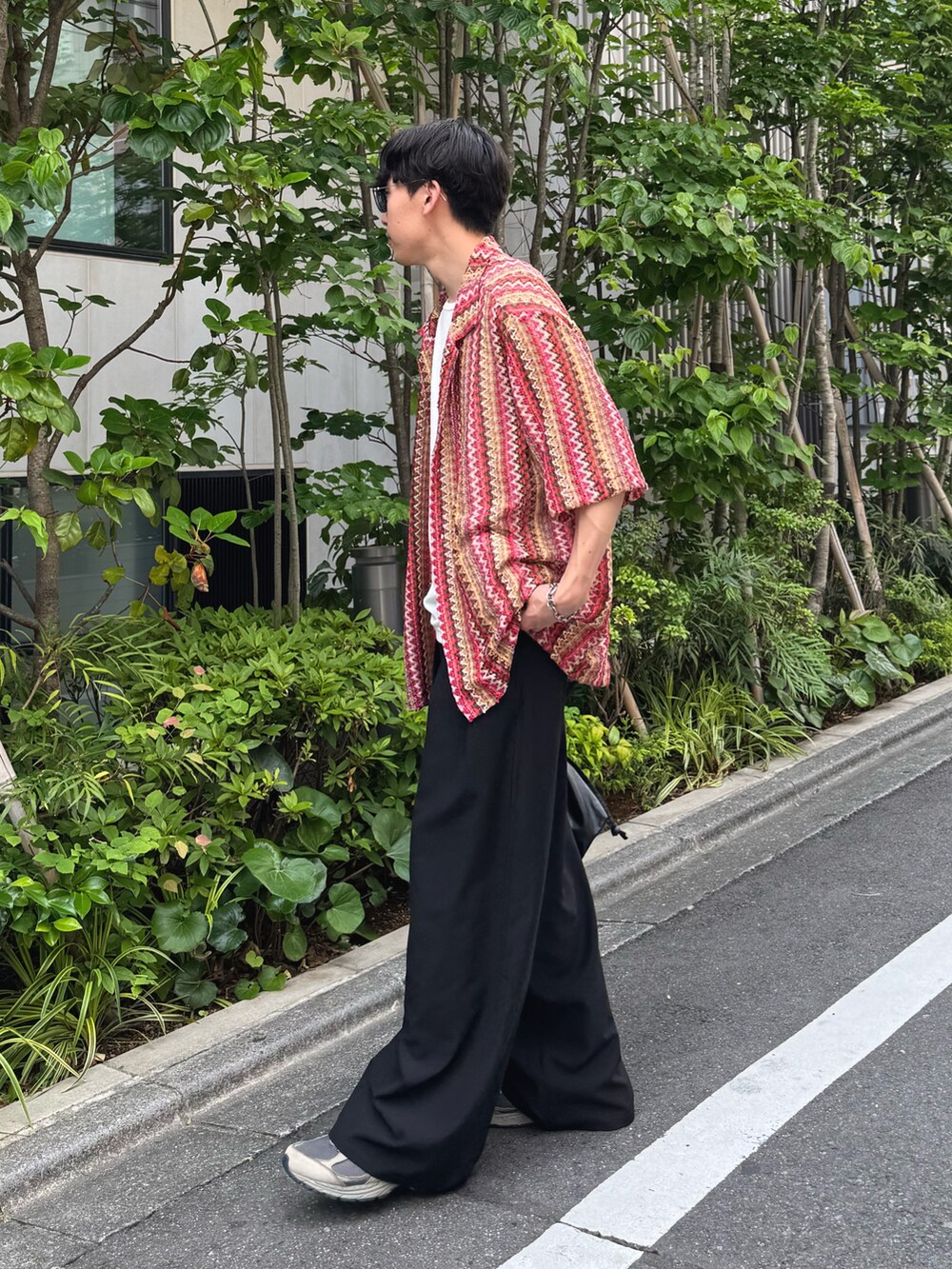 レッド系のシャツ/ブラウス、ホワイト系のタンクトップ、ブラック系のスラックスを着用したメンズの夏コーディネートの2枚目の写真
