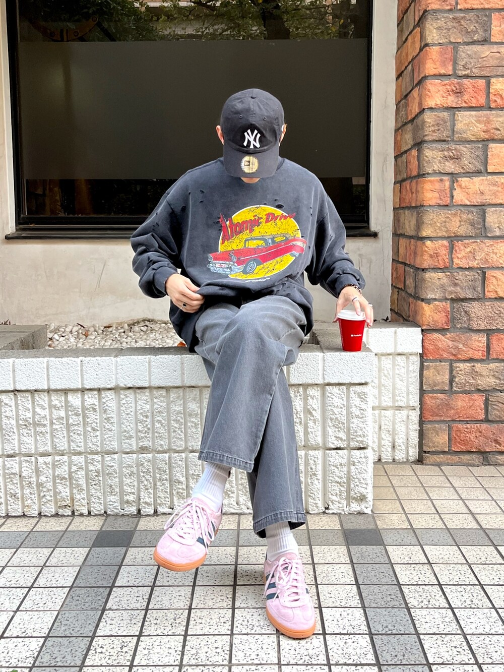 ブラック系のTシャツ/カットソー、ブラック系のデニムパンツ、ピンク系のスニーカーを着用したメンズの秋コーディネートの2枚目の写真