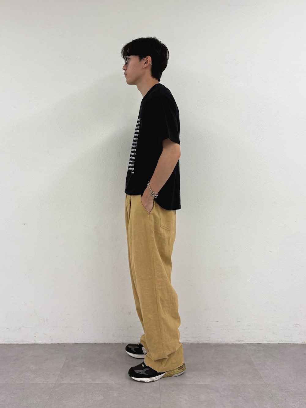 ブラック系のTシャツ/カットソー、ベージュ系のチノパンツを着用したメンズの夏コーディネートの2枚目の写真