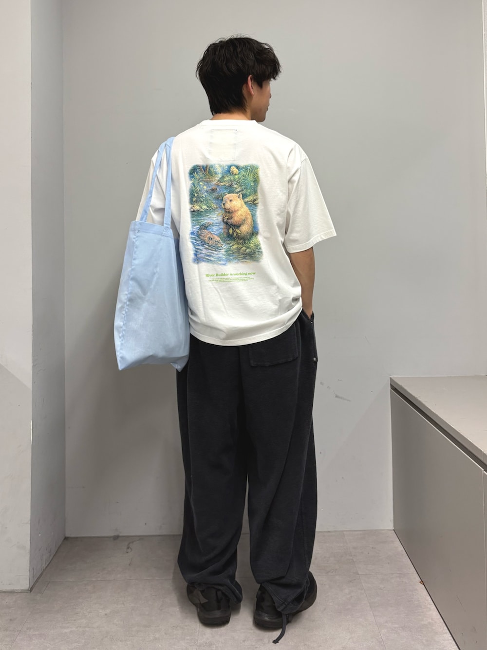 ホワイト系のTシャツ/カットソー、ブルー系のトートバッグ、ブラック系のその他パンツを着用したメンズの春コーディネートの3枚目の写真