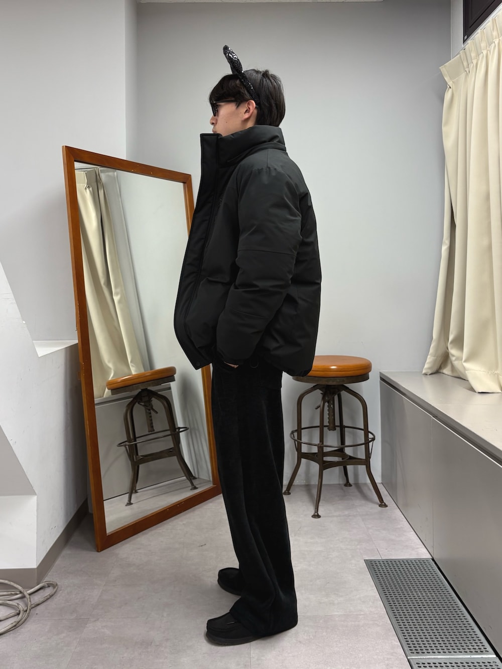 ブラック系のダウンジャケット/コート、ブルー系のニット/セーター、ブラック系のその他パンツを着用したメンズの秋コーディネートの2枚目の写真