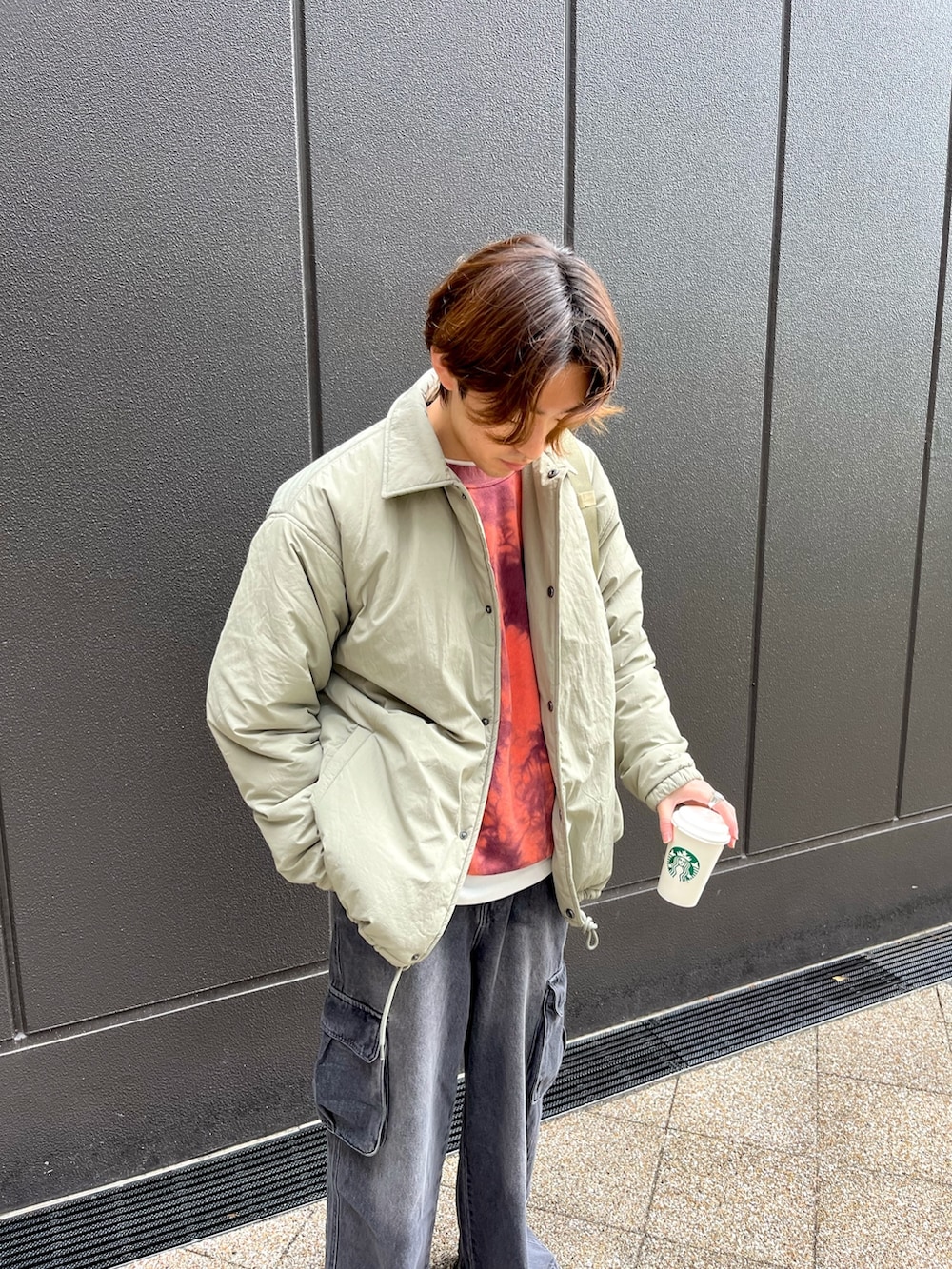 グレー系のスニーカー、ブラック系のカーゴパンツ、レッド系のスウェットを着用したメンズの冬コーディネートの3枚目の写真