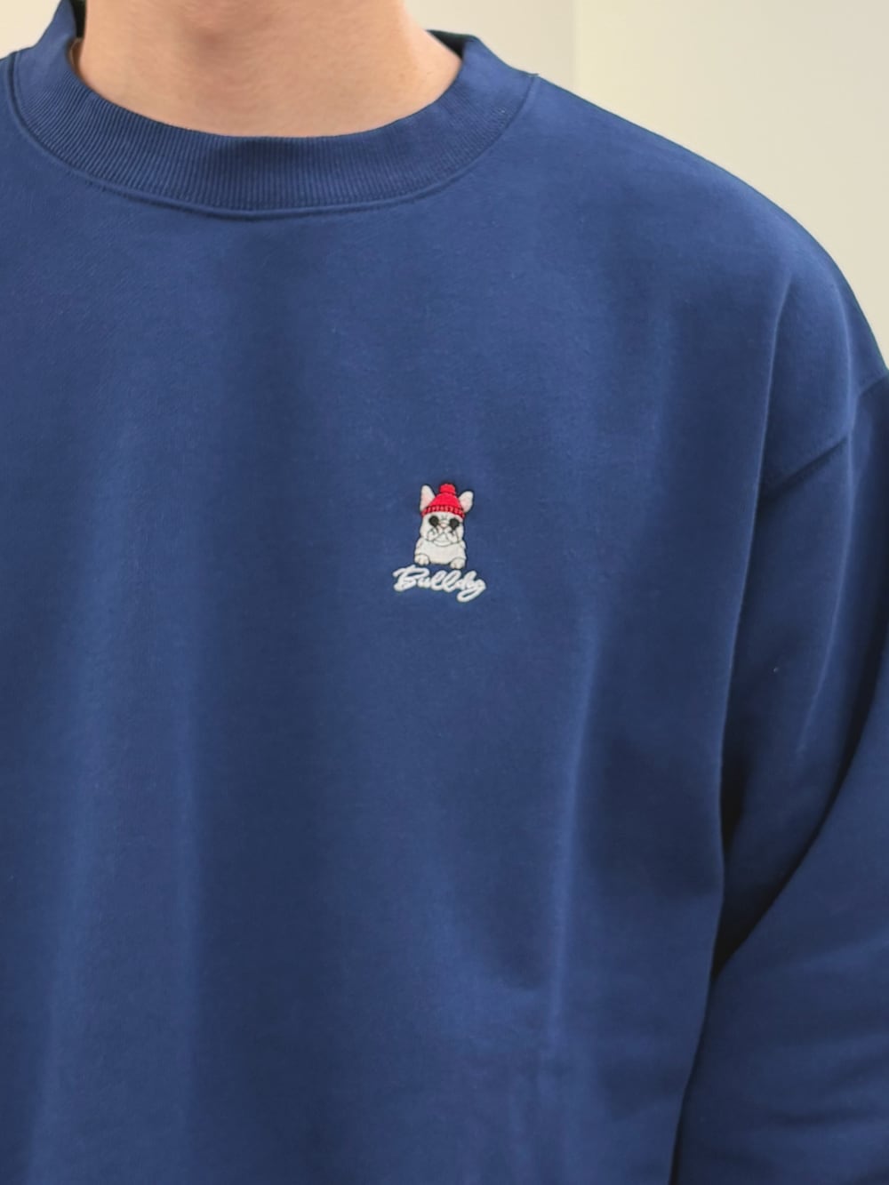 ブルー系のスウェット、ブラック系のスラックス、ブラック系のショルダーバッグを着用したメンズの春コーディネートの3枚目の写真