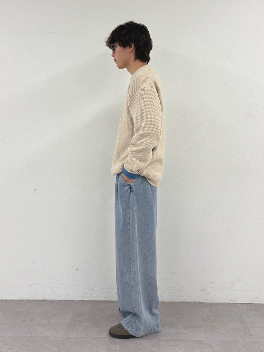 ホワイト系のニット/セーター、ブルー系のデニムパンツを着用したメンズの秋コーディネートの2枚目の写真