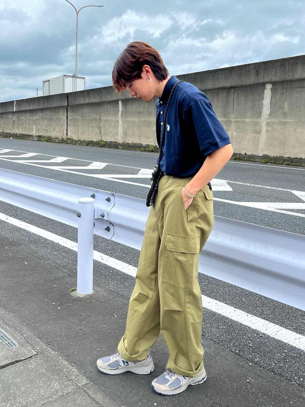 グレー系のスニーカー、グリーン系のカーゴパンツ、ブルー系のポロシャツを着用したメンズの夏コーディネートの2枚目の写真