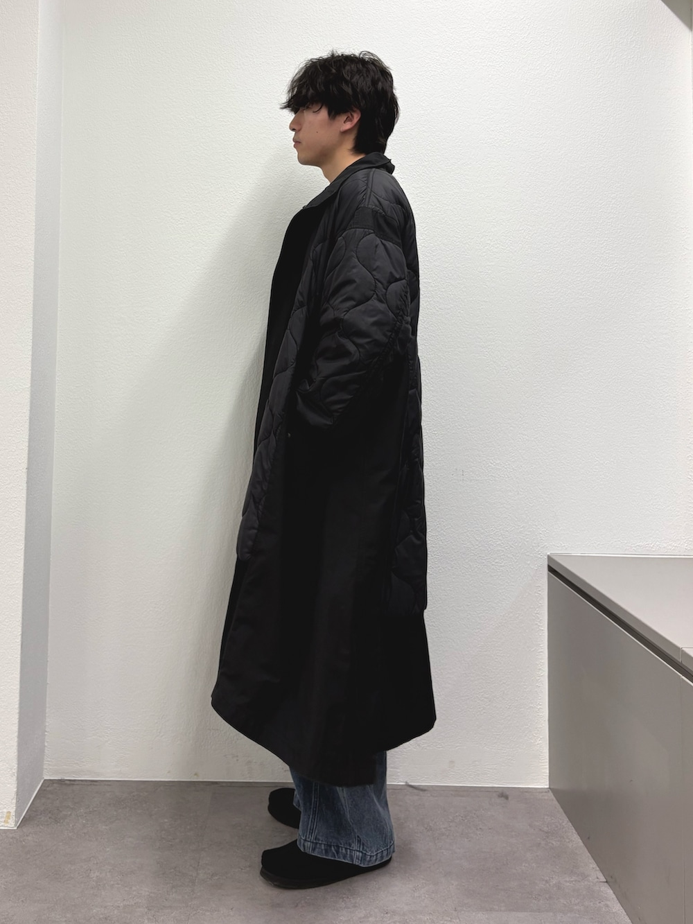 ブラック系のモッズコート、ブラック系のスウェット、ブルー系のデニムパンツを着用したメンズの冬コーディネートの2枚目の写真