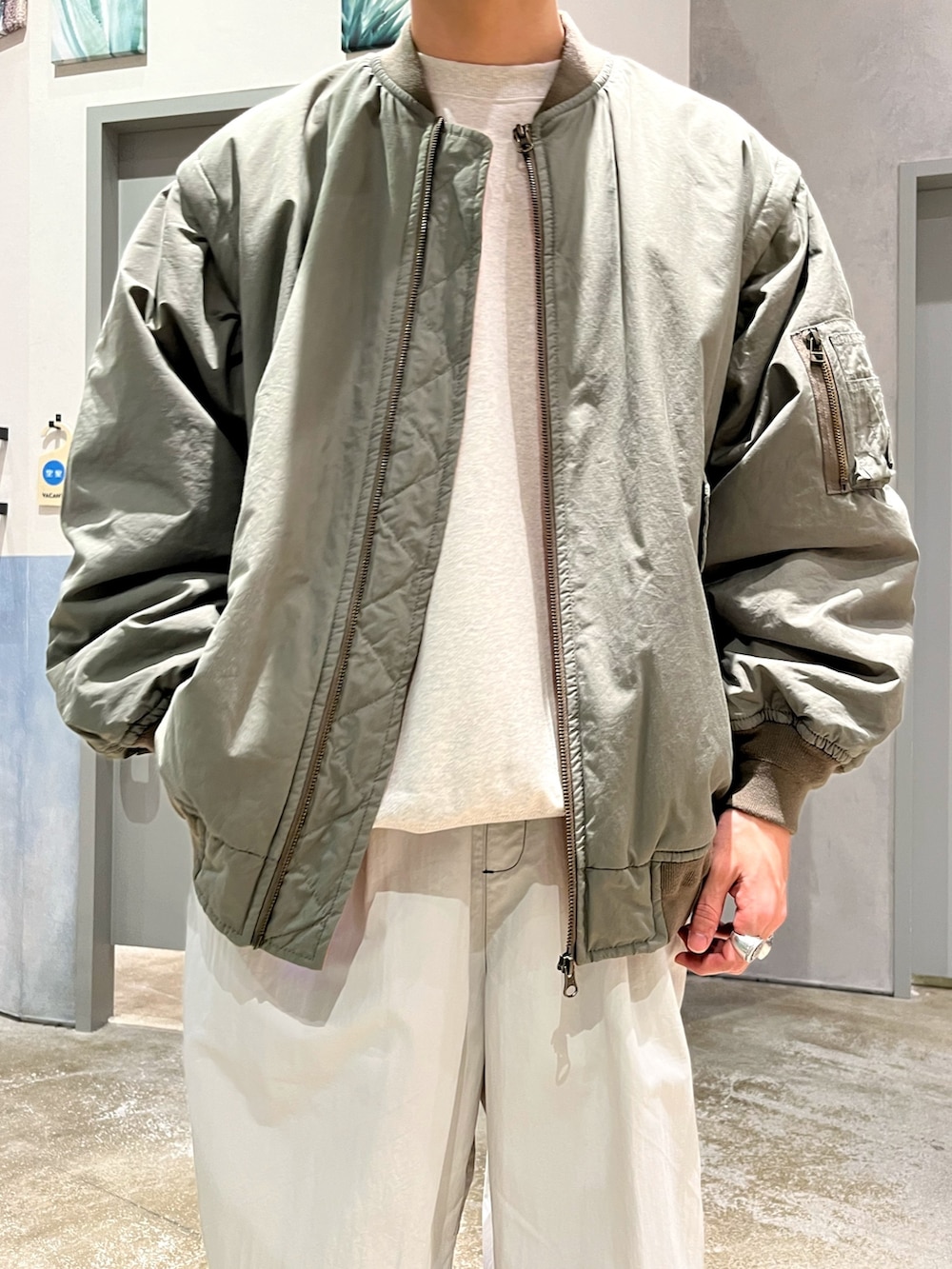 グレー系のスニーカー、グレー系のカーゴパンツ、ホワイト系のスウェットを着用したメンズの冬コーディネートの3枚目の写真