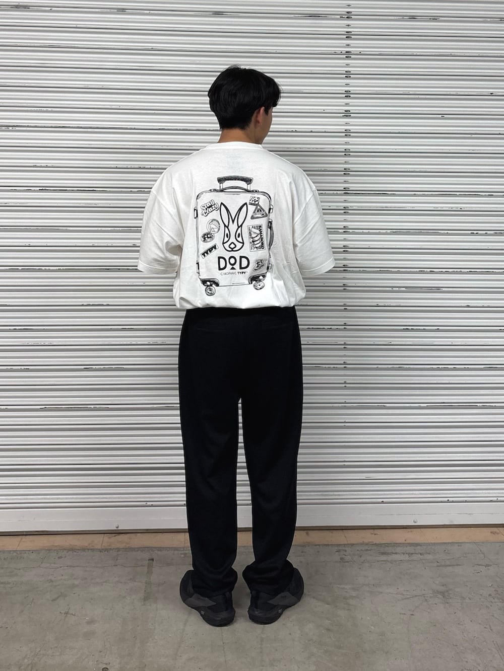 ホワイト系のTシャツ/カットソー、ブラック系のスラックスを着用したメンズの春コーディネートの2枚目の写真