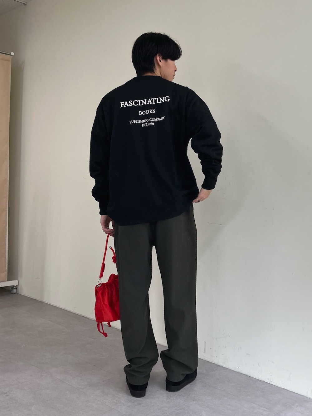 レッド系のショルダーバッグ、ブラック系のTシャツ/カットソー、グリーン系のスーツパンツを着用したメンズの秋コーディネートの2枚目の写真