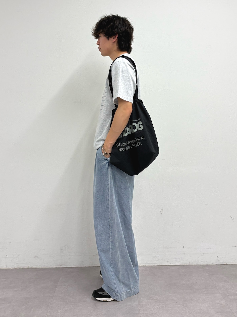 グレー系のTシャツ/カットソー、ブラック系のトートバッグ、ブルー系のデニムパンツを着用したメンズの夏コーディネートの2枚目の写真