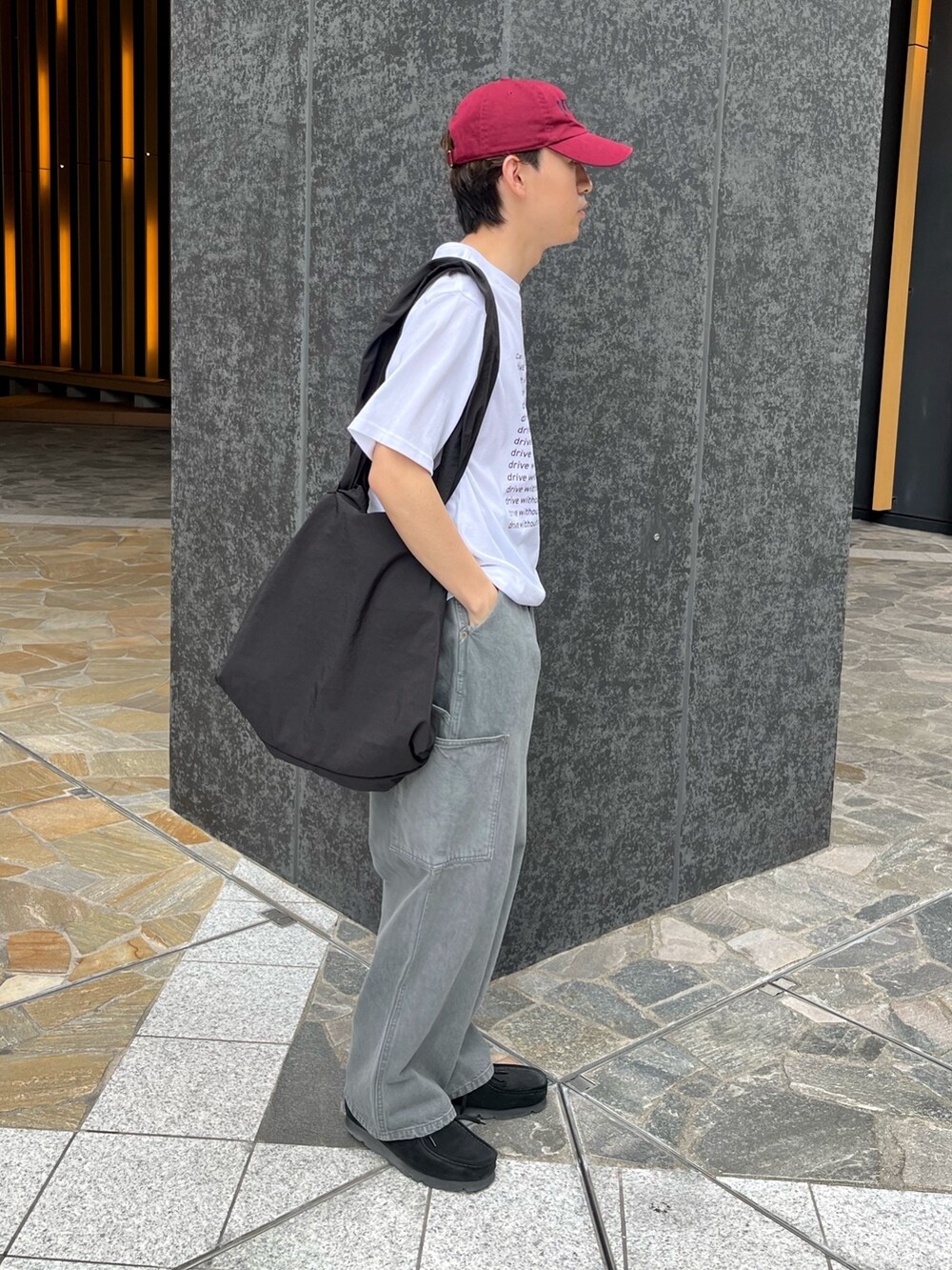 ブラック系のスニーカー、グレー系のデニムパンツ、グレー系のTシャツ/カットソーを着用したメンズの春コーディネートの2枚目の写真