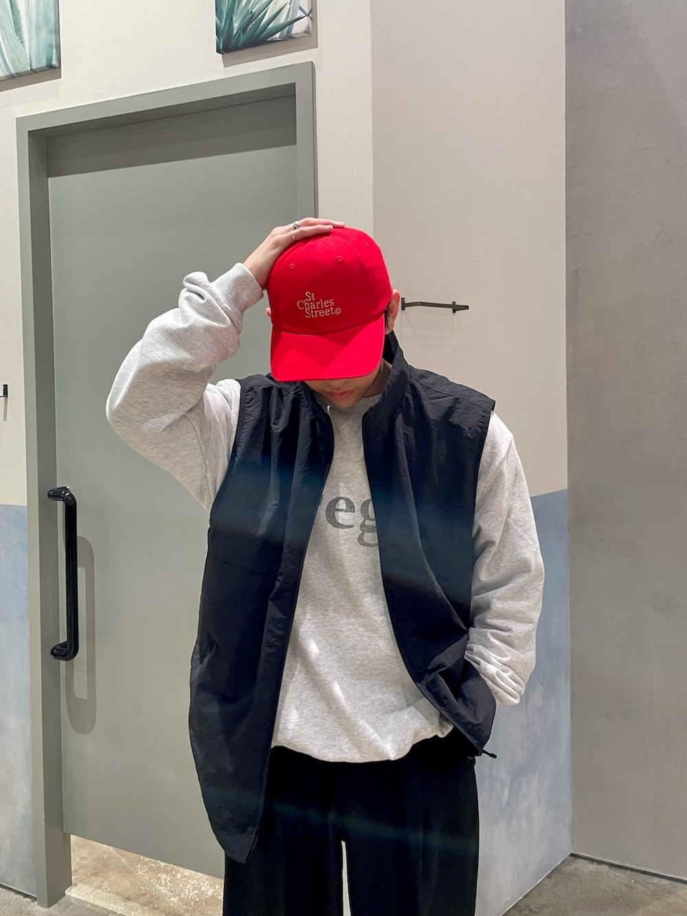 ブラック系のスニーカー、ブラック系のスラックス、ブラック系のベストを着用したメンズの春コーディネートの3枚目の写真