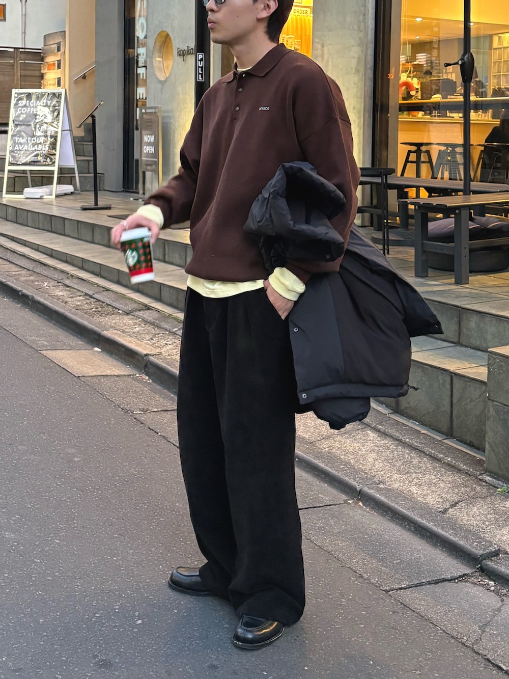 ブラウン系のニット/セーター、イエロー系のTシャツ/カットソー、ブラック系のその他パンツを着用したメンズの冬コーディネートの2枚目の写真